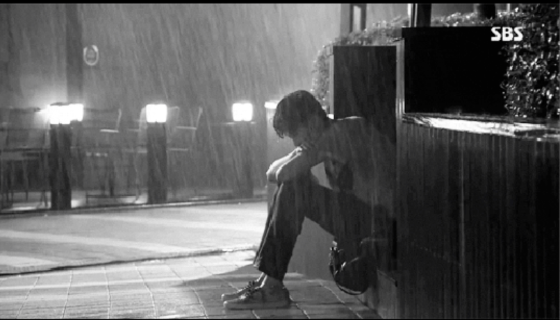 Boy, sitting in the rain
